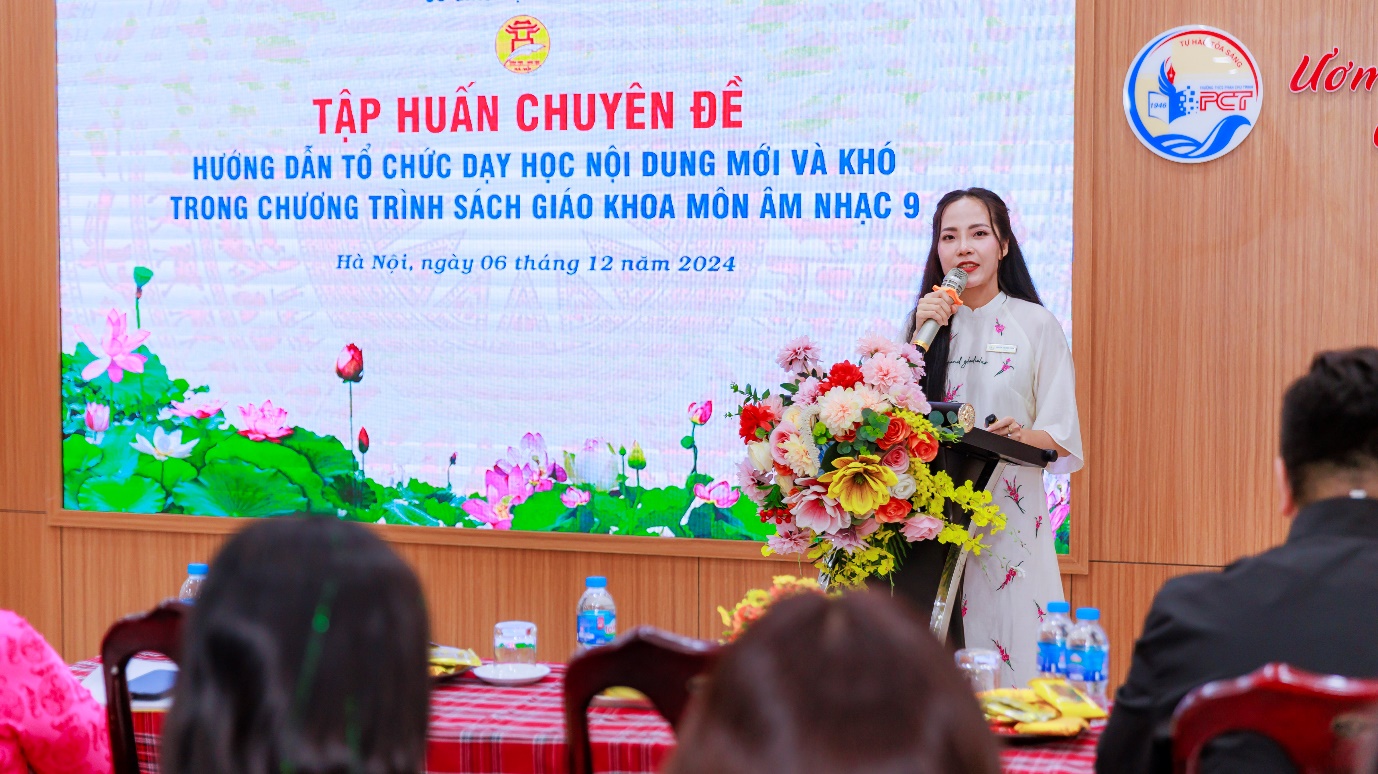 A person standing at a podium with a microphone and flowers

Description automatically generated