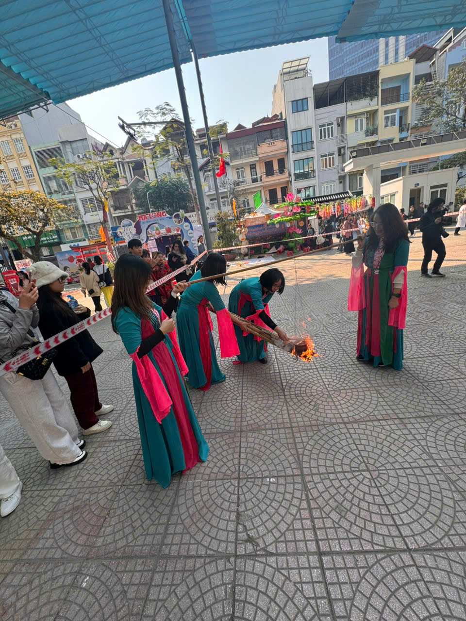 A group of people in dresses holding a fire

Description automatically generated