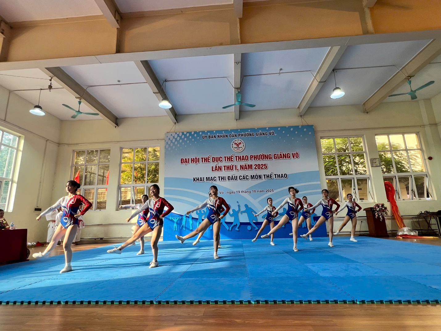 A group of cheerleaders performing on a blue mat
AI-generated content may be incorrect.