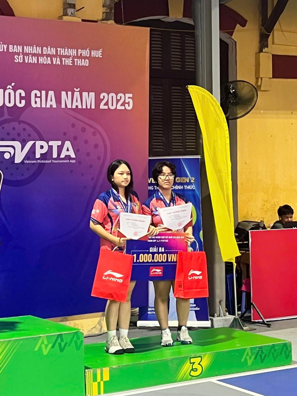 Two people standing on a podium holding signs

AI-generated content may be incorrect.
