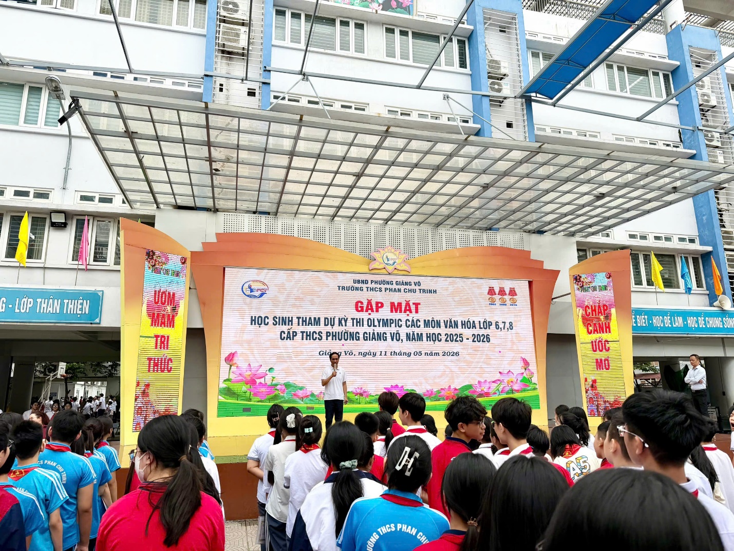 A group of people standing in front of a large banner

AI-generated content may be incorrect.