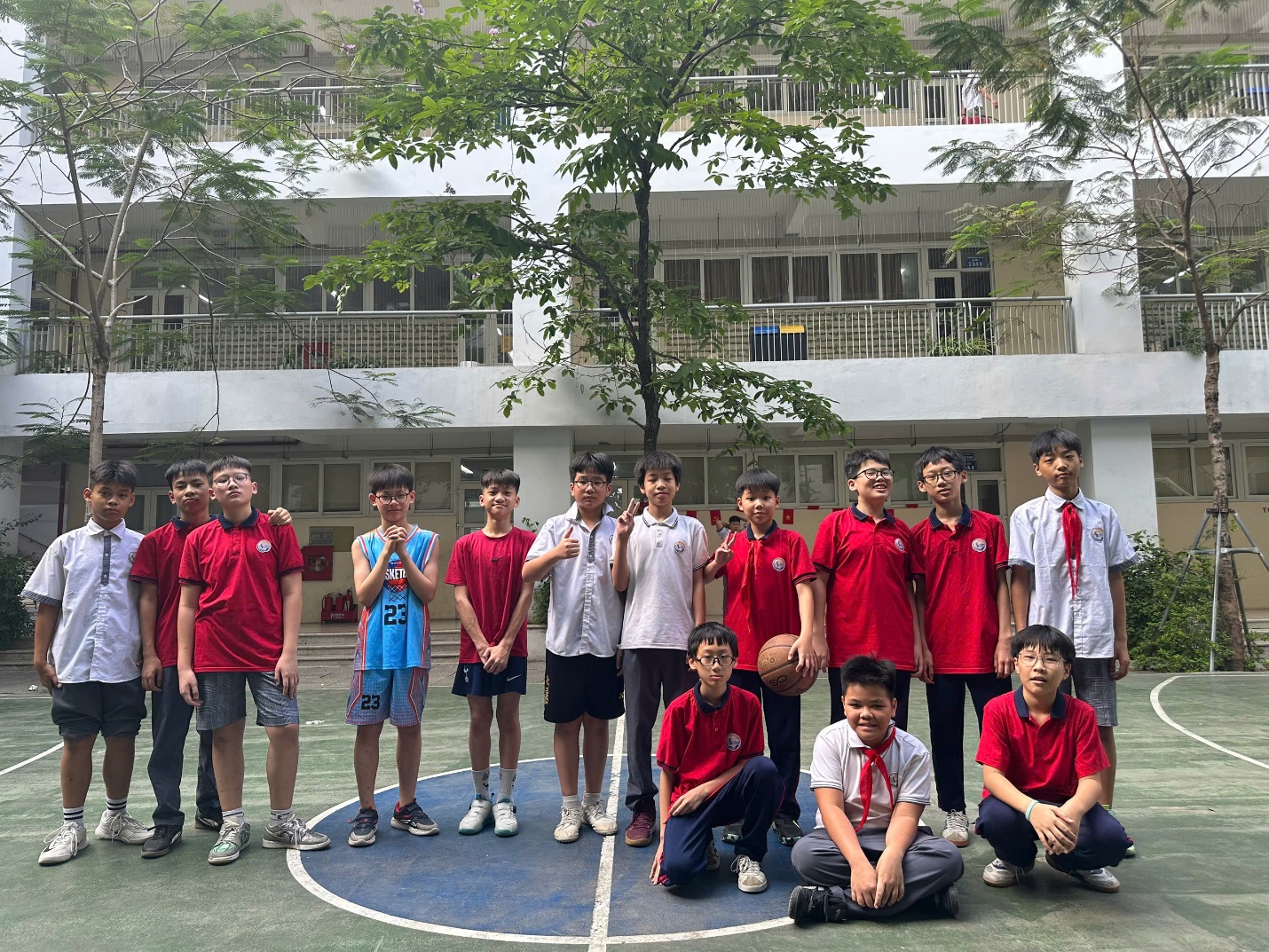 A group of boys in red shirts and blue shorts standing on a basketball court

AI-generated content may be incorrect.