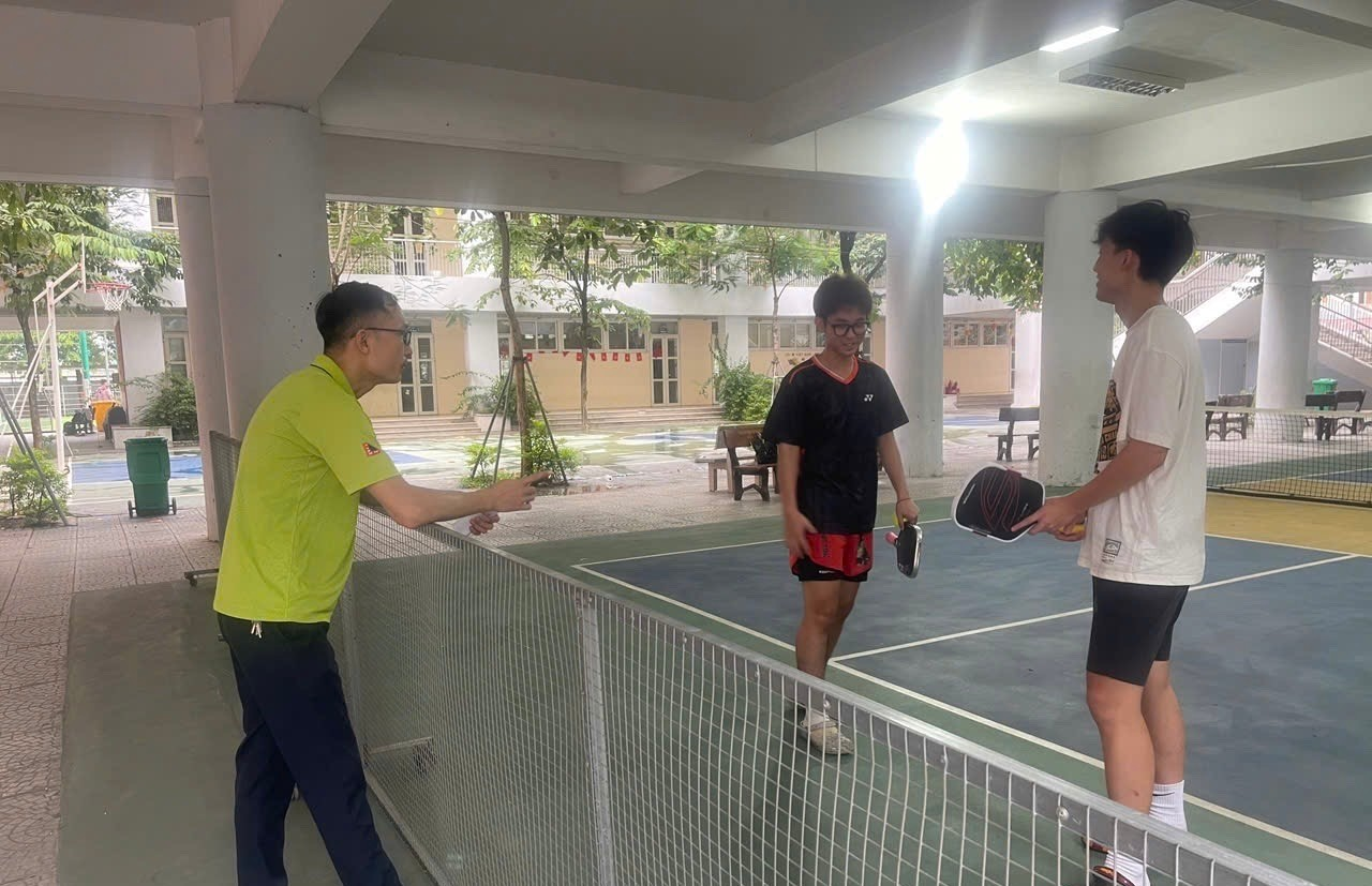 A group of people standing next to a tennis courtAI-generated content may be incorrect.