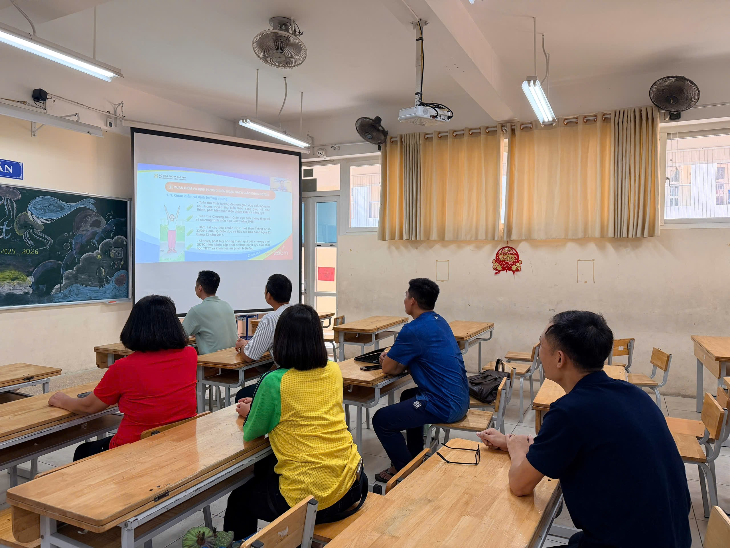 A group of people sitting at desks in a classroomAI-generated content may be incorrect.